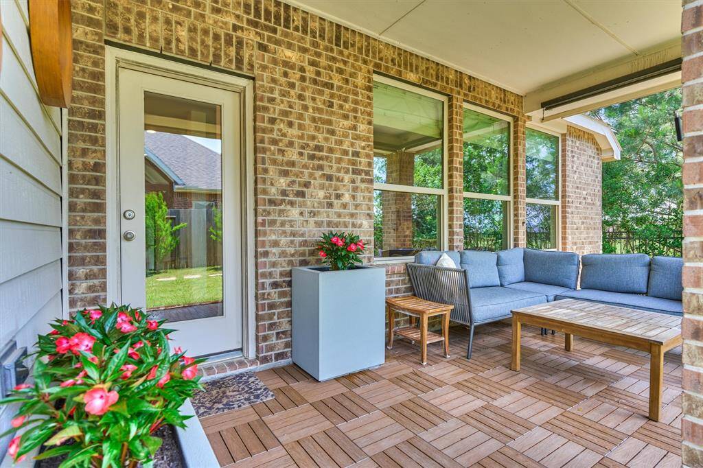 Supreme outdoor living with this covered patio featuring composite tile decking and retractable shades for added privacy.