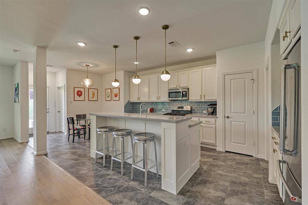 This kitchen is an absolute showstopper with breakfast bar seating, large walk-in pantry, quartz counters and complementary backsplash!