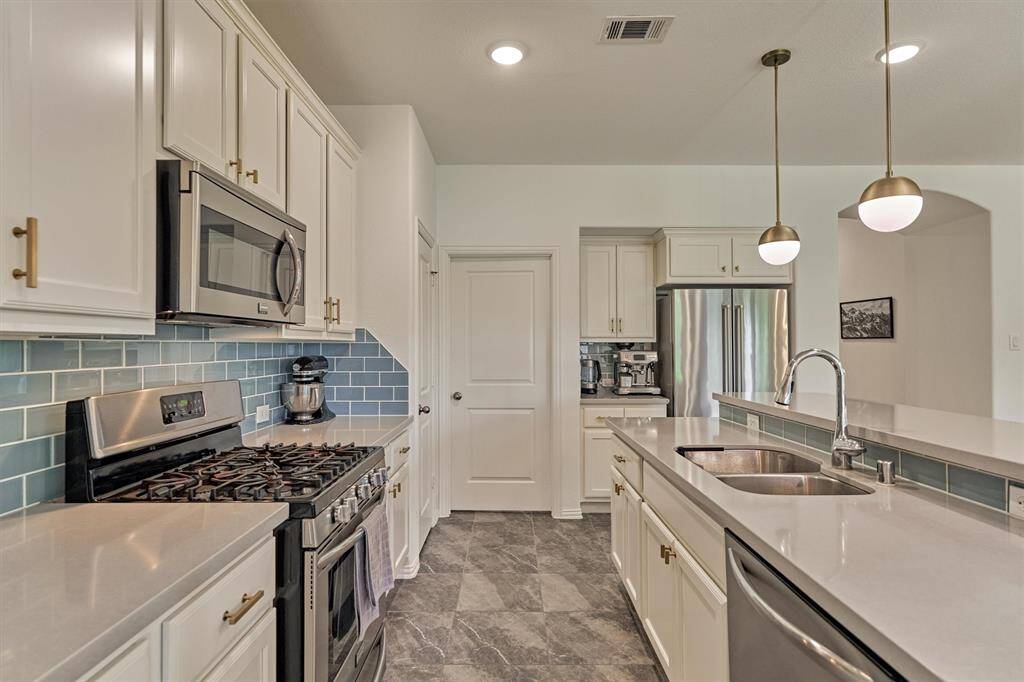 Sleek counters align with upgraded hardware and striking light fixtures to create this eye-catching space.