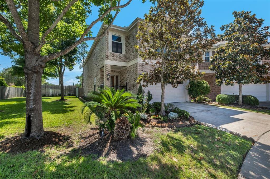 Lush green space on left side of home.