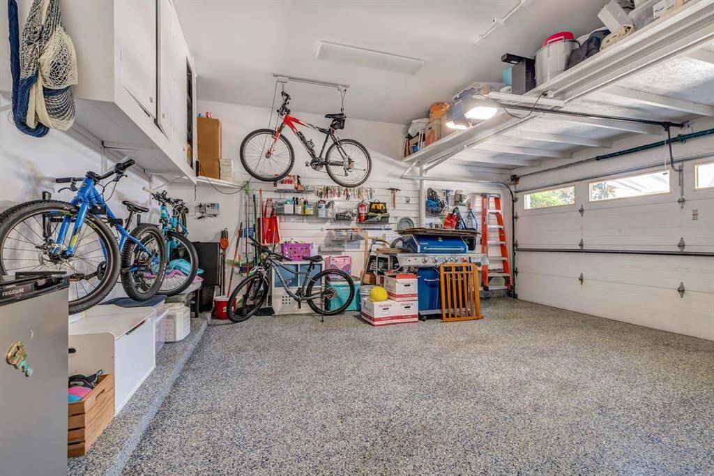 Garage floor has epoxy coating and elevated storage shelves.
