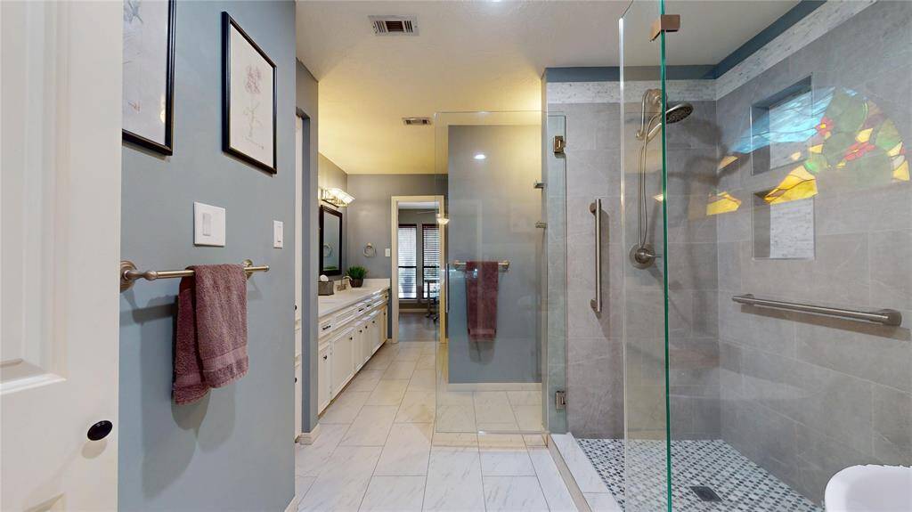 Stunning remodeled primary suite featuring a freestanding soaking tub and double vanity.