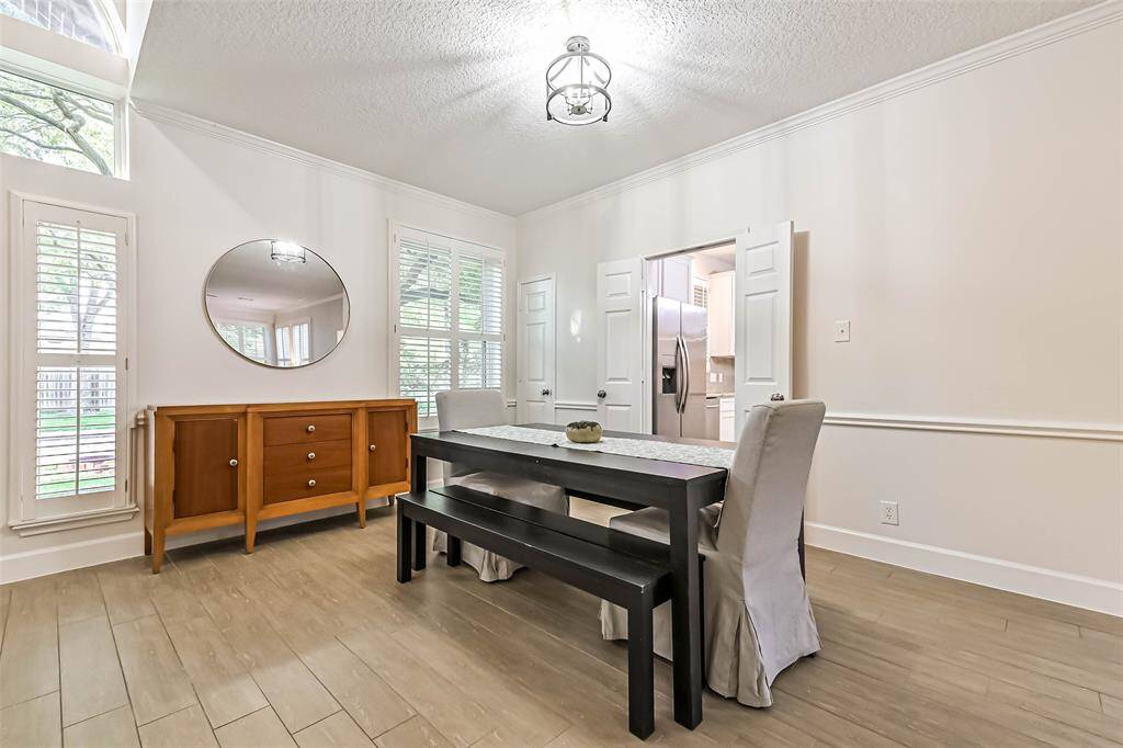 Another view of the formal dining room shows the plantation shutters and entry to the kitchen through the double doors. There is also a coat closet.