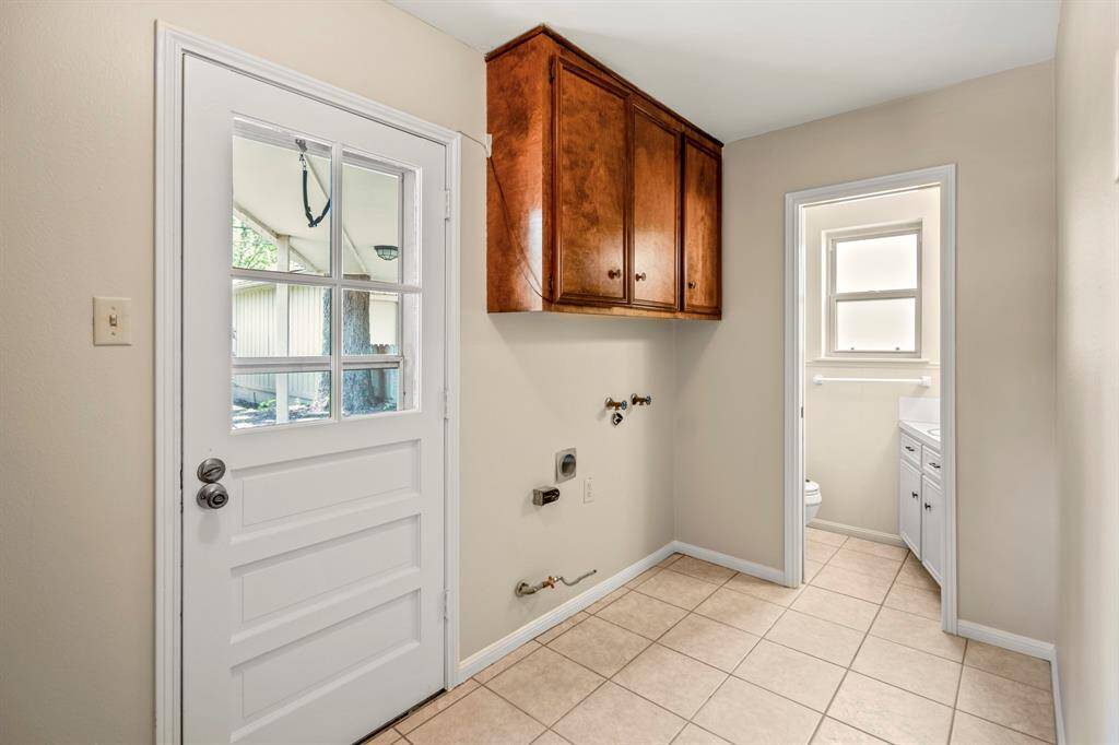 Spacious laundry room with backyard access and a tucked-away powder bath—functional and convenient for busy households.
