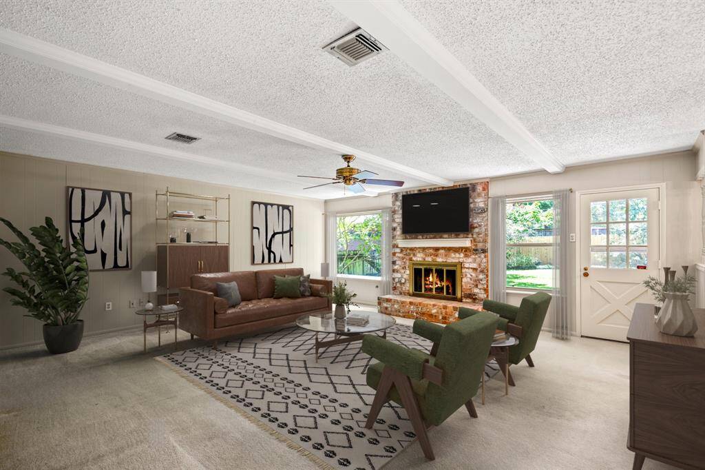 Full of charm and character, this family room offers a gas fireplace, wood beam accents, built-in shelves, and large windows overlooking the backyard. - VIRTUALLY STAGED