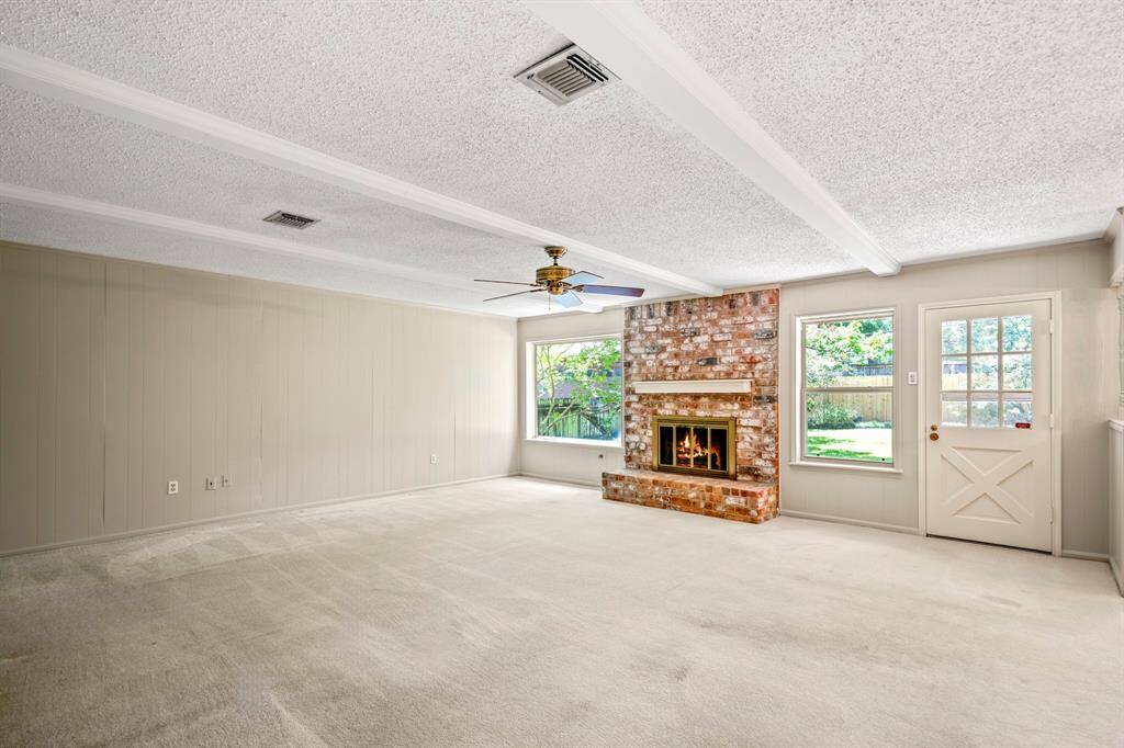 Full of charm and character, this family room offers a gas fireplace, wood beam accents, built-in shelves, and large windows overlooking the backyard.