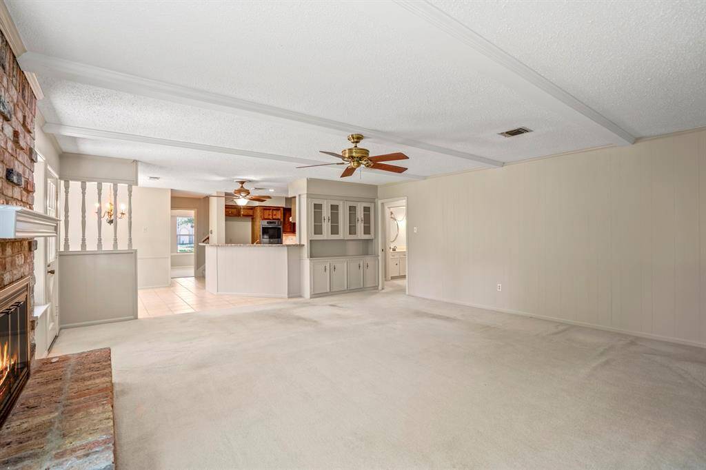 Full of charm and character, this family room offers a gas fireplace, wood beam accents, built-in shelves, and large windows overlooking the backyard.