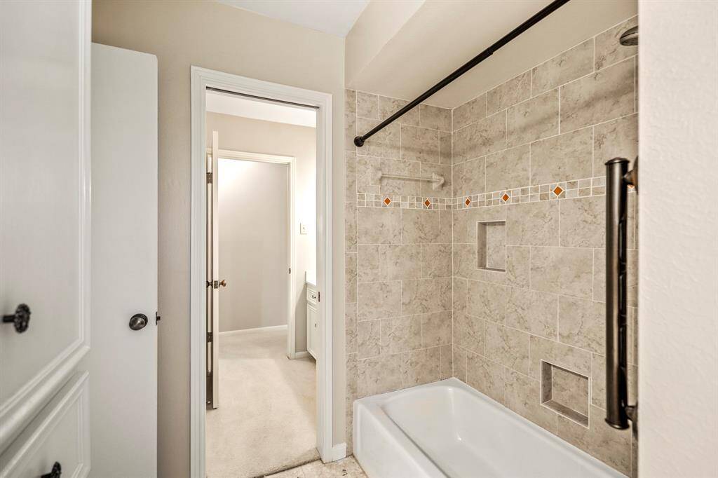 Enjoy a functional layout in the primary bath with a tub/shower combo, built-in shelving, and dual vanity access.