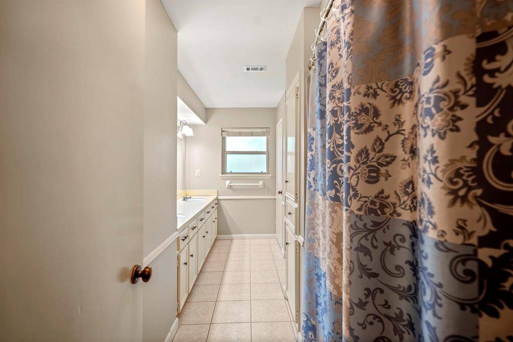Roomy second bathroom with double sinks, great storage, and a classic shower/tub combo—perfect for busy mornings.