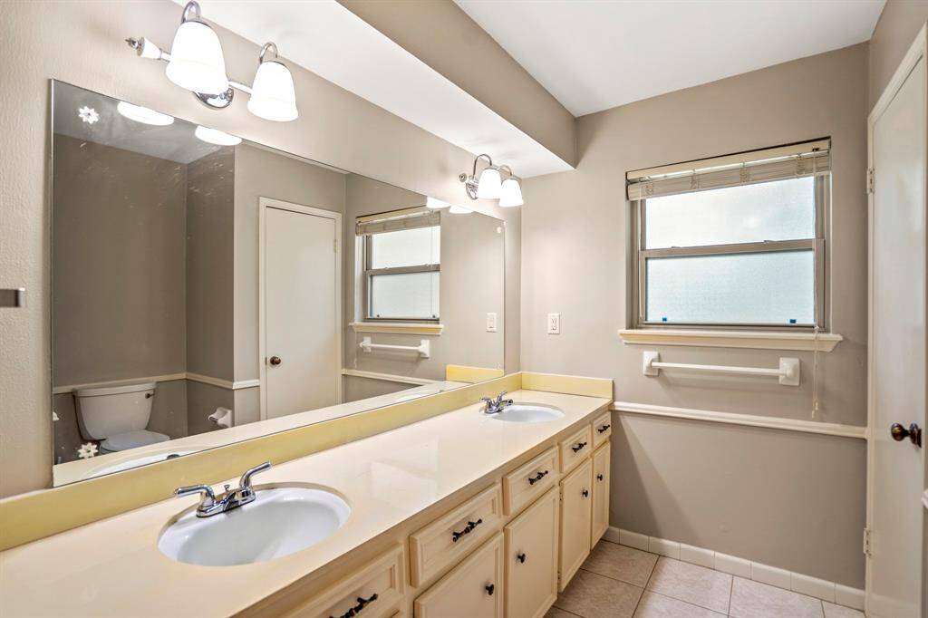 Roomy second bathroom with double sinks, great storage, and a classic shower/tub combo—perfect for busy mornings.