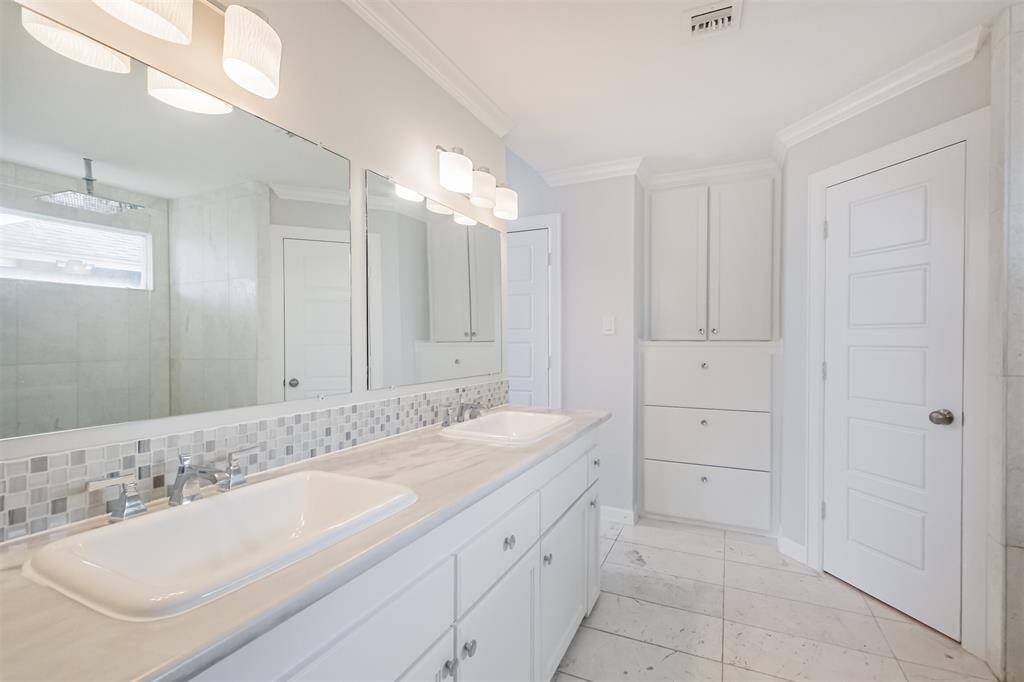 The primary bathroom has been updated with quartz counters (2016), tile floors and tile backsplash. There are double sinks, built-in linen cabinets and 3 closets.