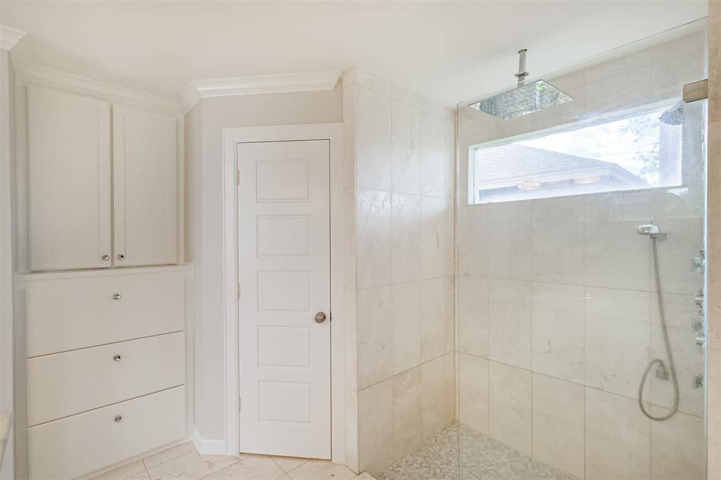 The primary shower has updated tile surround and a rainfall shower head.