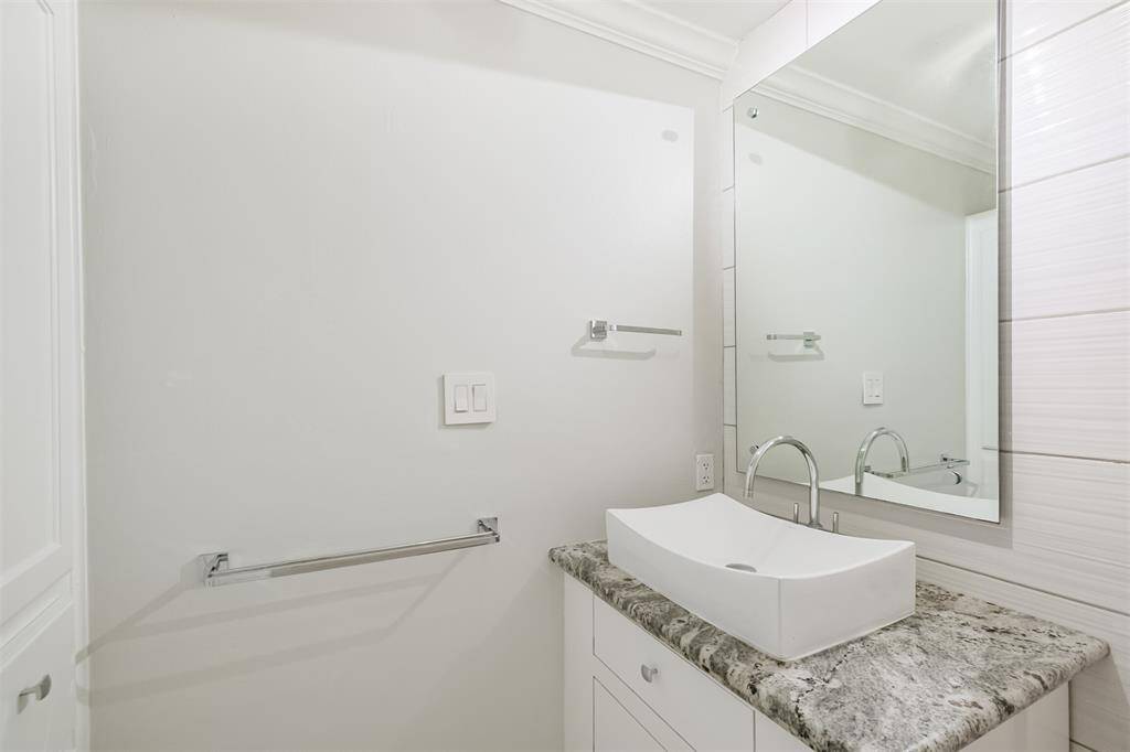The second full bathroom has an updated vanity with granite counters and tile floors.