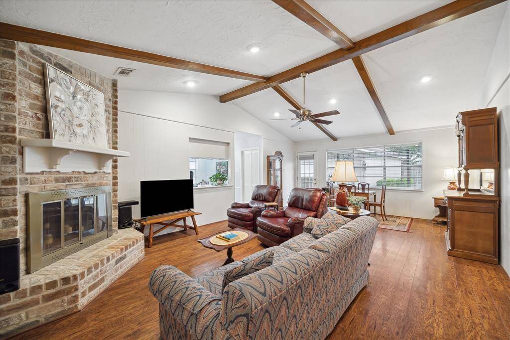 Large and open Family Room is warm and inviting! The room boasts wood beams, laminate flooring, wood burning fireplace and neutral paint.