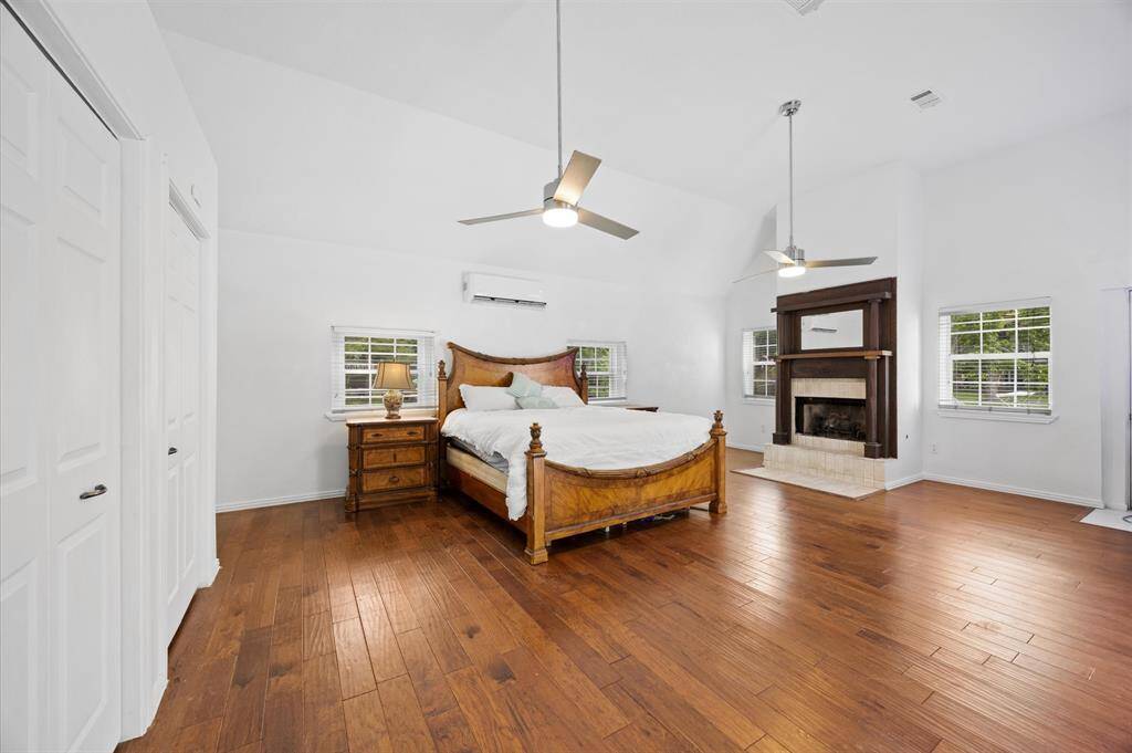 Experience luxury in the spacious first-floor primary bedroom, featuring high ceilings, abundant natural light, and a cozy fireplace for ultimate comfort.