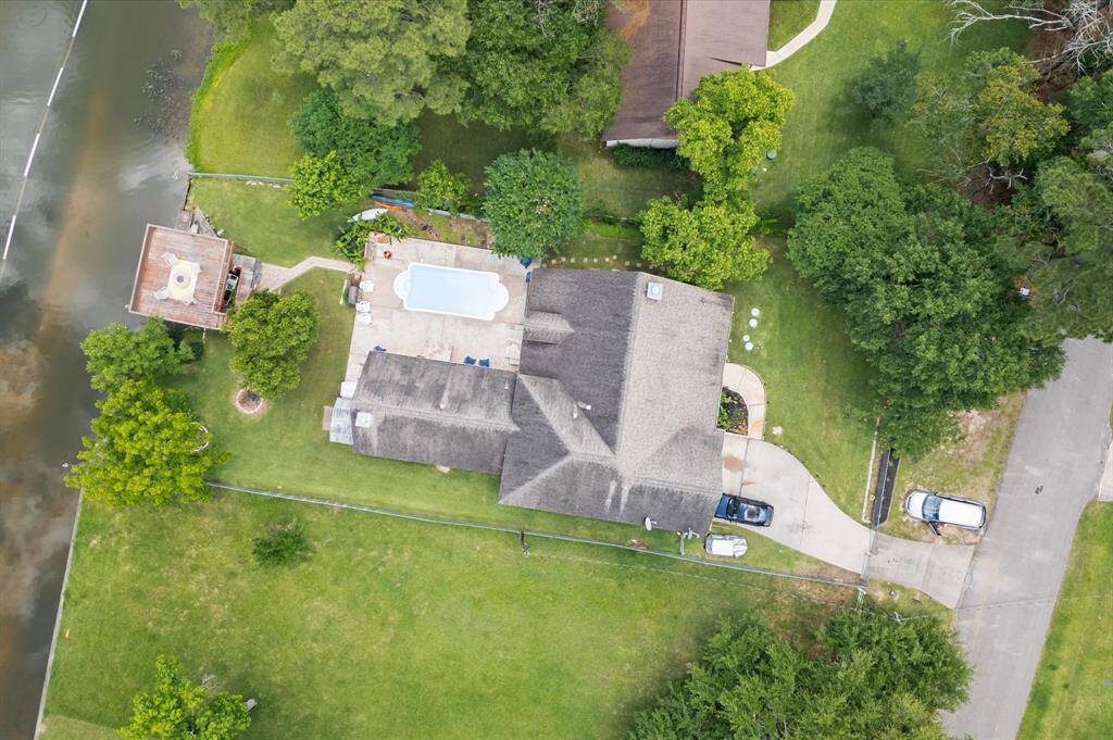 Waterfront property featuring a well-maintained home with a backyard pool. Enjoy tranquil views, ample parking, and enhanced privacy with lush surrounding trees.