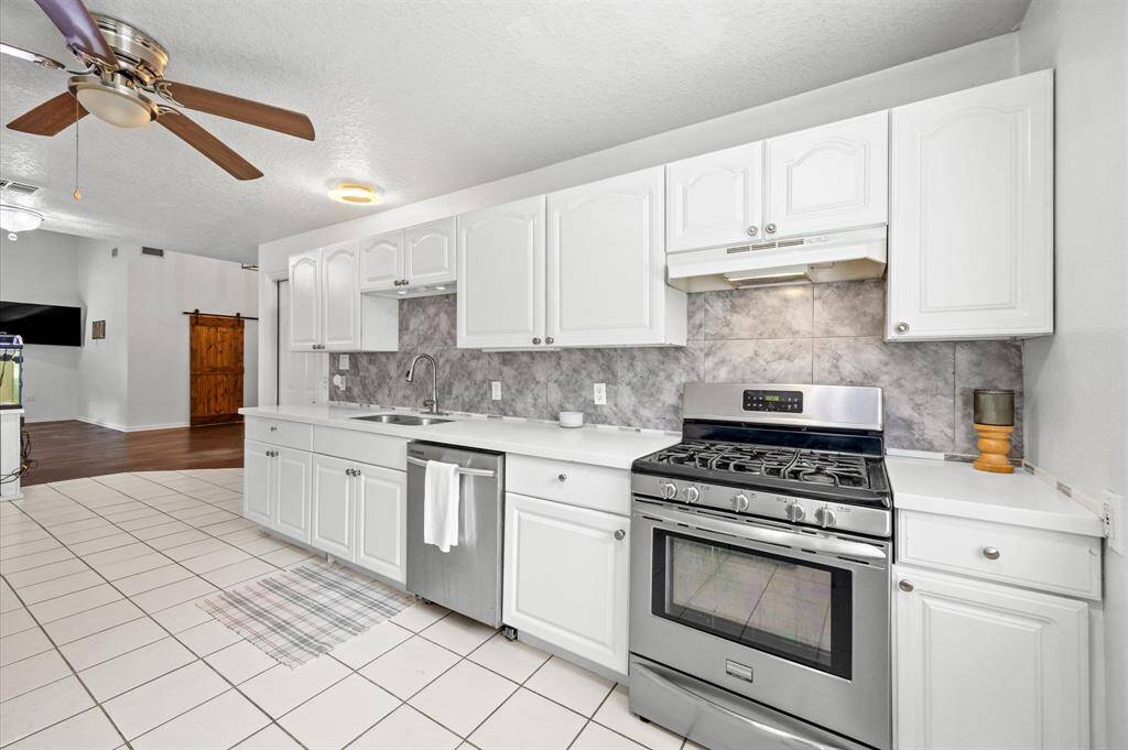 Modern kitchen with a stylish tiled backsplash and seamless flow into the living area.