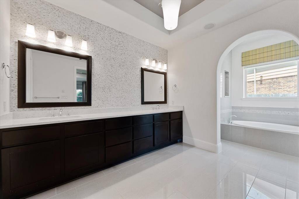Luxurious ensuite primary bath with dual sinks, ample storage.