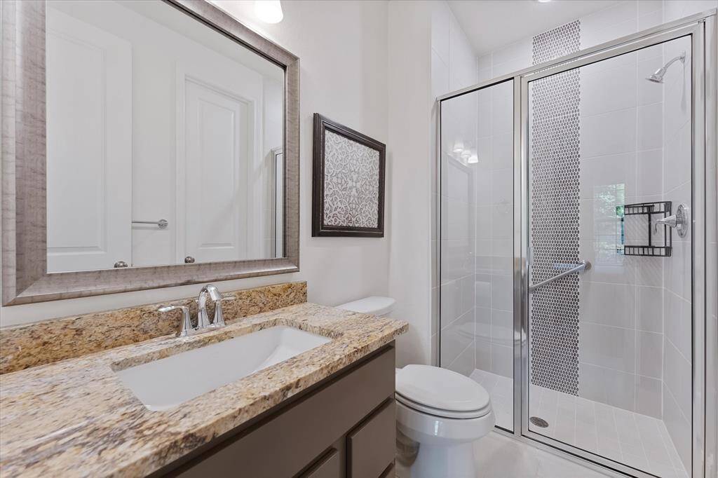 Ensuite guest room bath with granite countertop and walk-in shower