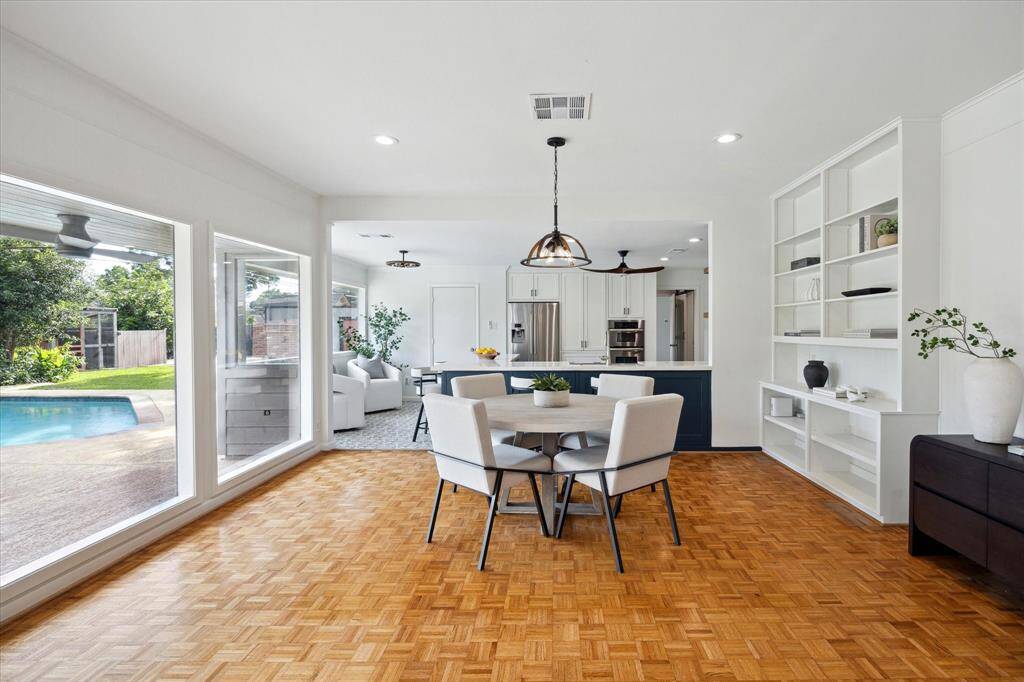 The breakfast area is thoughtfully positioned opposite the kitchen. Bathed in natural light from the floor-to-ceiling windows, this inviting space provides the perfect setting for enjoying meals.