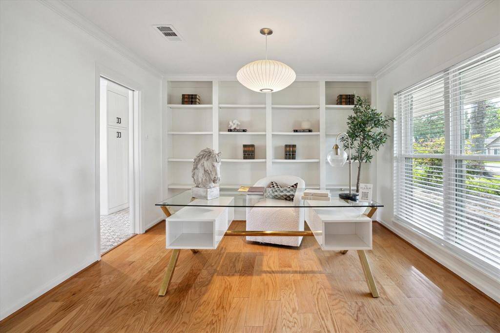 This bright and stylish home office offers built-in shelving, a statement chandelier, and stunning views of the front yard—perfect for inspired productivity.