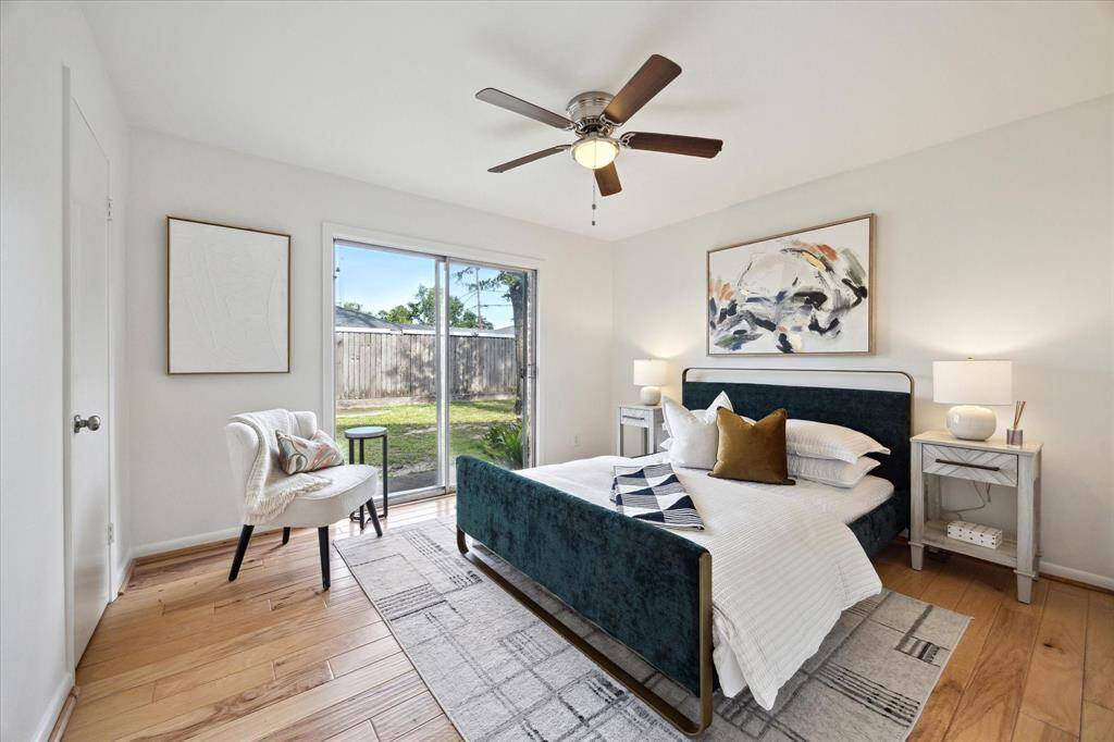 Secondary bedroom with a large window overlooking the yard, walk-in closet, ceiling fan with light.