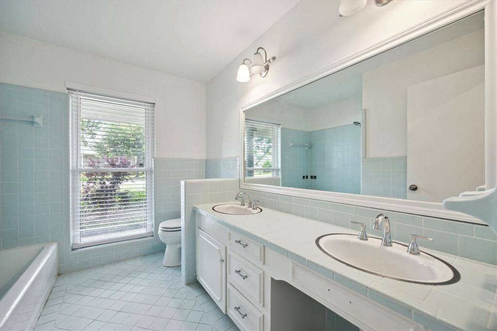 Hall bath with double sinks and a shower/tub combo.
