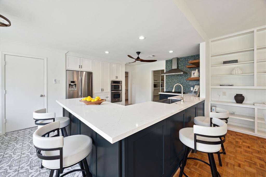 The kitchen, beautifully updated in 2021*, is the heart of the home and features quartz countertops, a glass tile backsplash, a stainless-steel apron front sink and a HUGE walk-in pantry. *per seller.