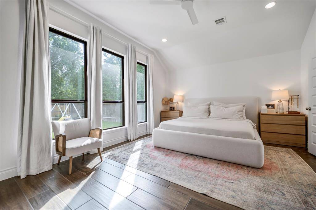 The stunning primary bedroom suite offers views of the backyard.