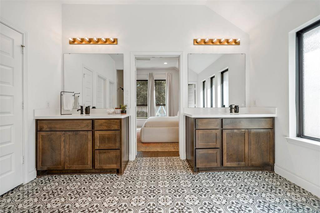 The primary bath features dual vanities, upgraded faucets and fixtures, and custom tile flooring.