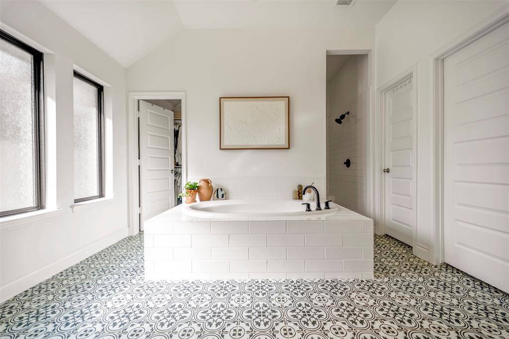 Enjoy a large soaking tub with a beautiful tile surround in the primary bath.