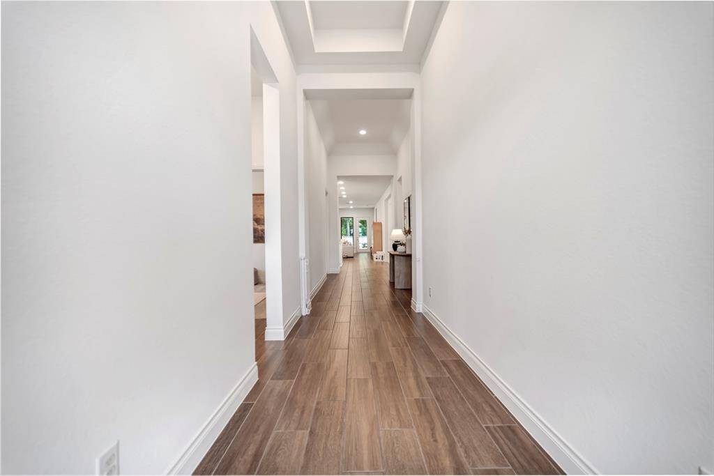 The elongated hallway from the foyer features stunning tray ceiling details.