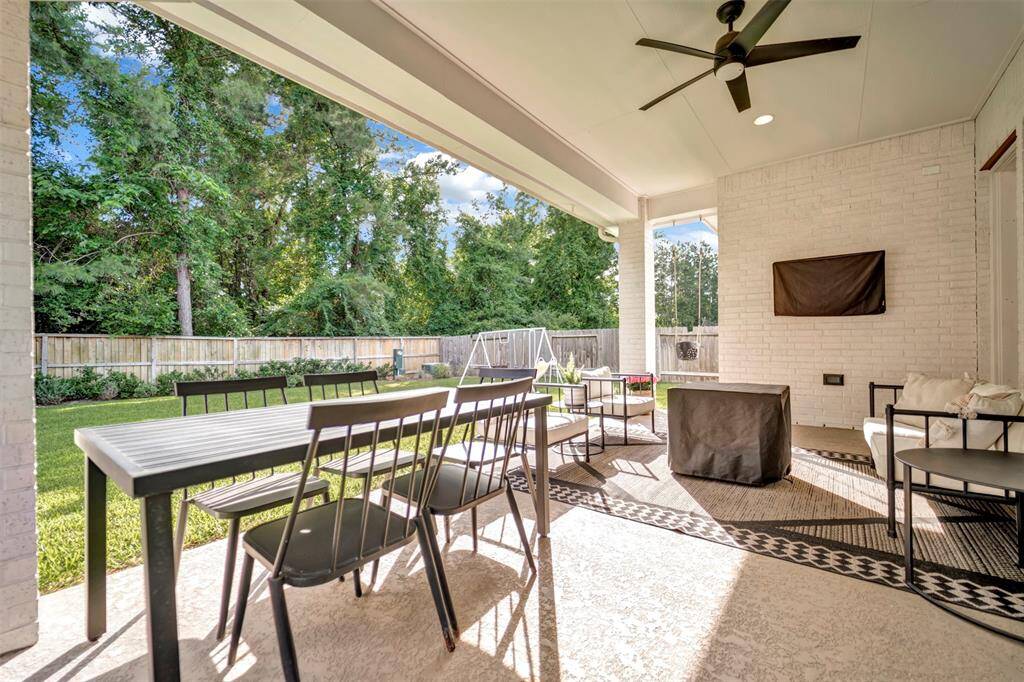 Relax on the extended covered back patio, complete with a ceiling fan and scenic views of mature trees.