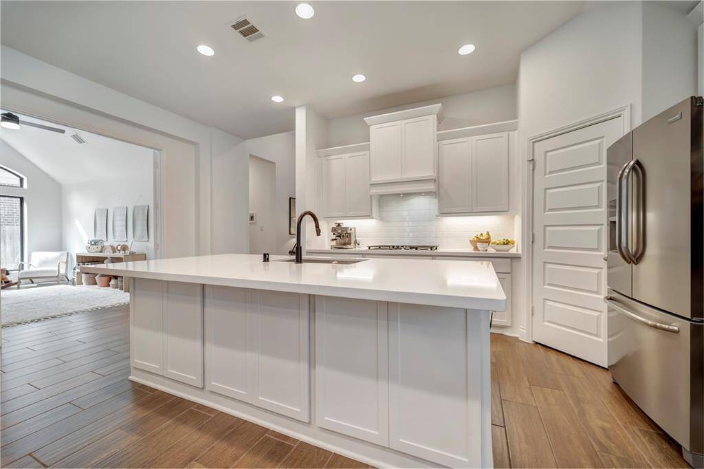 The gourmet kitchen features high-end stone countertops.