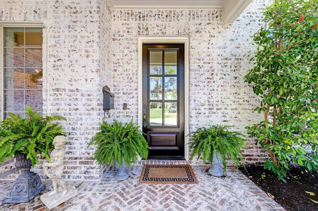 Charming front porch with soldi wood 6 panel front door, German schmear brick flooirng and gas lanterns.