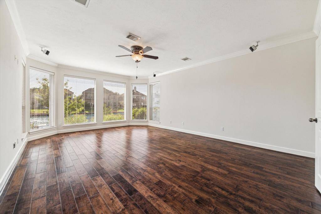 Primary bedroom suite with hardwood floors and a sitting area in front of the expansive windows that look at to the lake. Surround sound speakers  included.