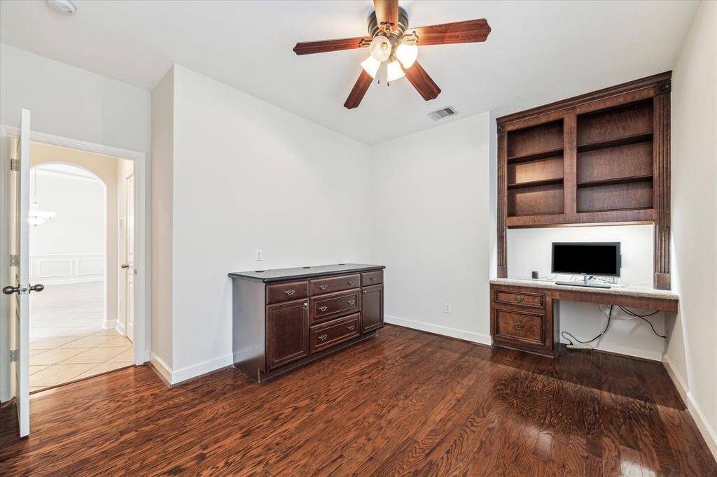 Office with hardwood floors and built-ins.