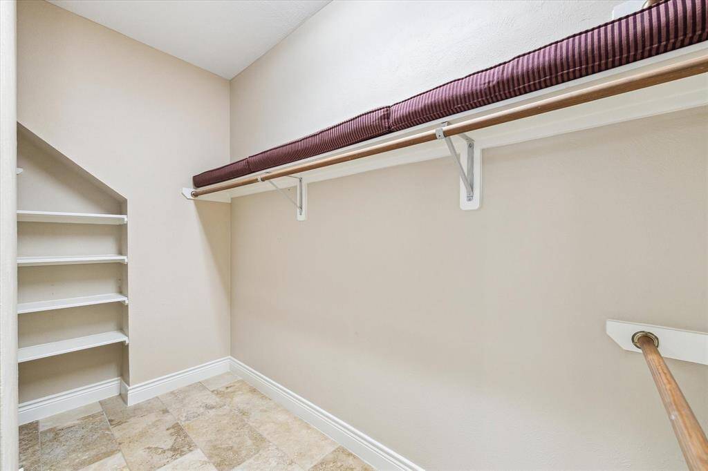 Primary closet with built in shelves.