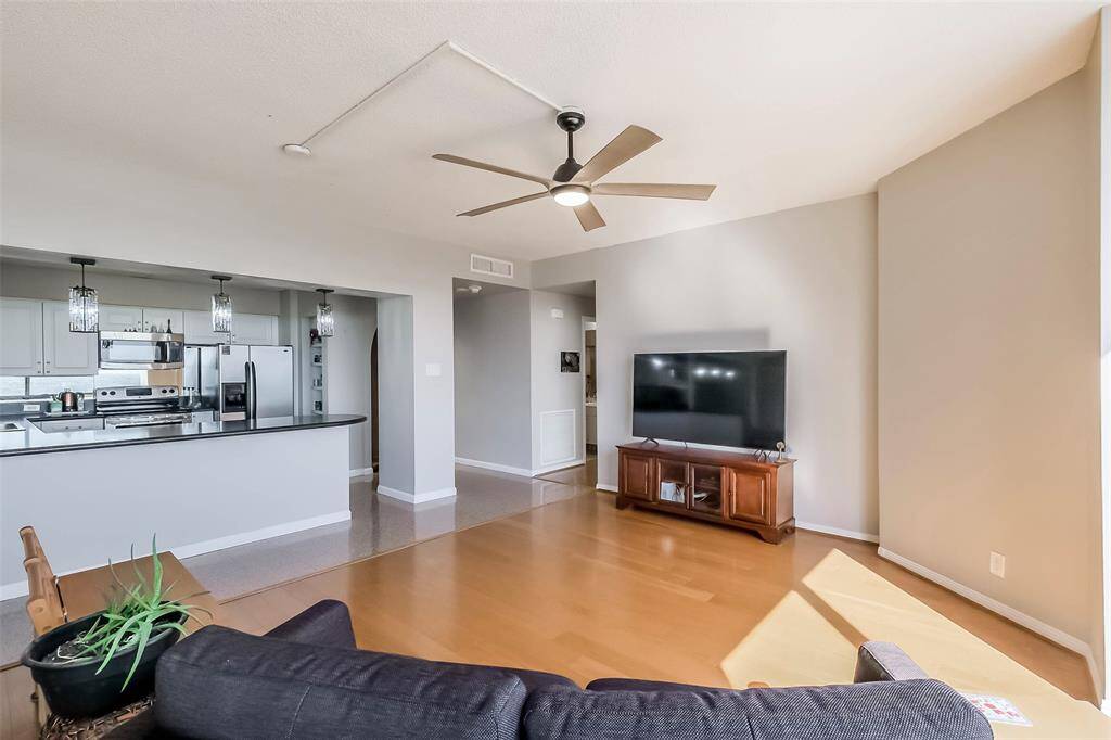 The kitchen overlooks the freshly painted living area accented with wood floors.