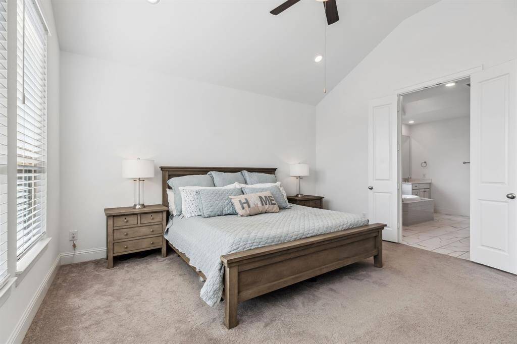 Primary bedroom with vaulted ceiling with view into the a HUGE primary bath and massive walk in closet !