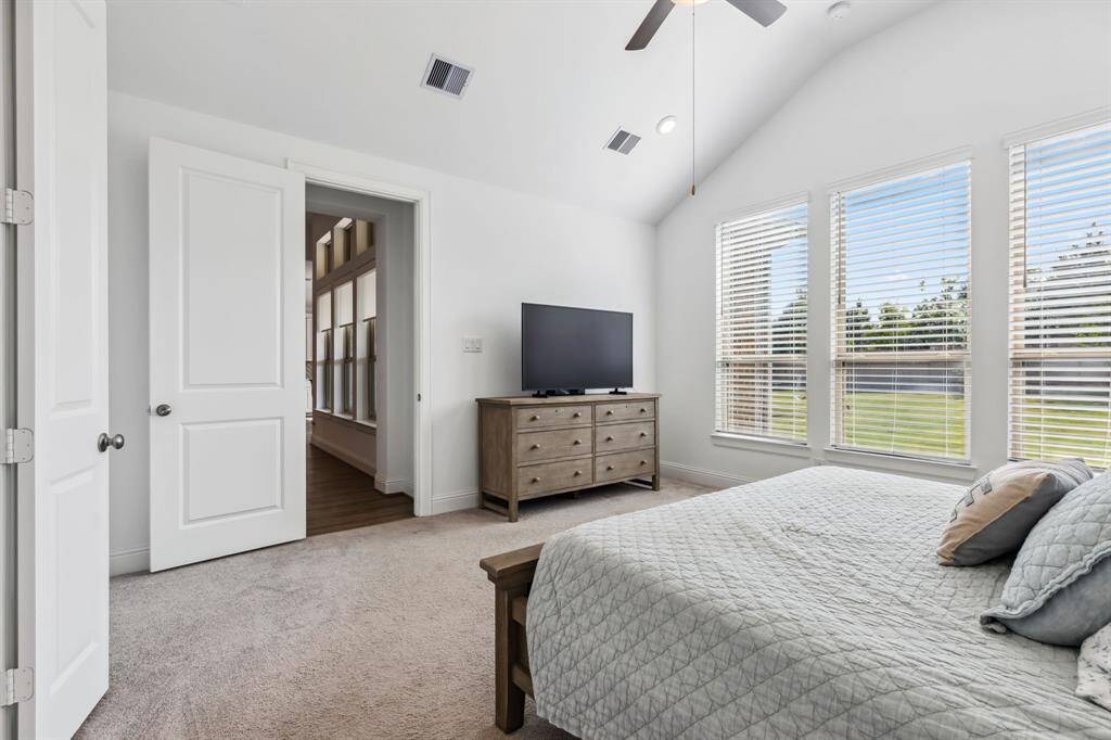 Primary with vaulted ceiling.  Views into the backyard.