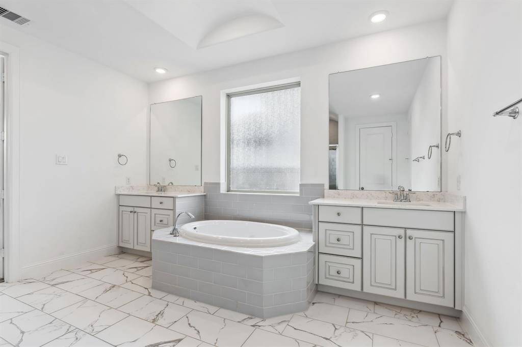 Love these beautiful floors and notice the vaulted ceiling between the vanities !  Don't miss the walk in closet that adjoins the laundry room.  Talk about convenient!