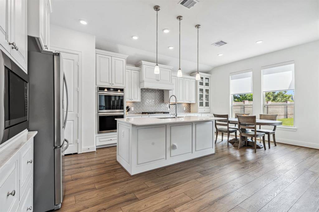 Island kitchen with double ovens, gas range, quartz counters, tons of cabinet and pantry storage and beautiful LVP Flooring.