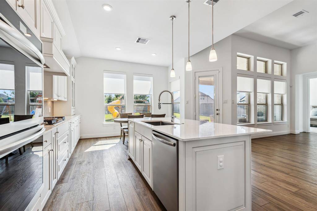 Kitchen is nice and bright with beautiful quartz countertops cabinets that go all the way up to the ceiling. Opens to the living area.
