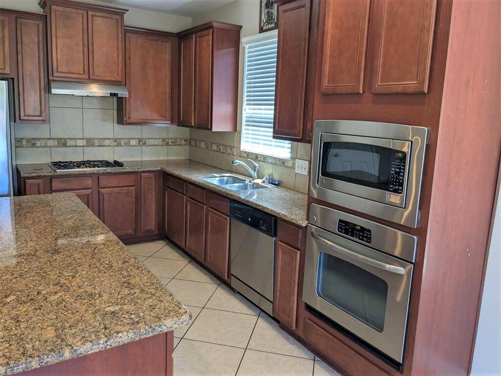 Elegant kitchen with custom backsplash and stunning granite countertops.