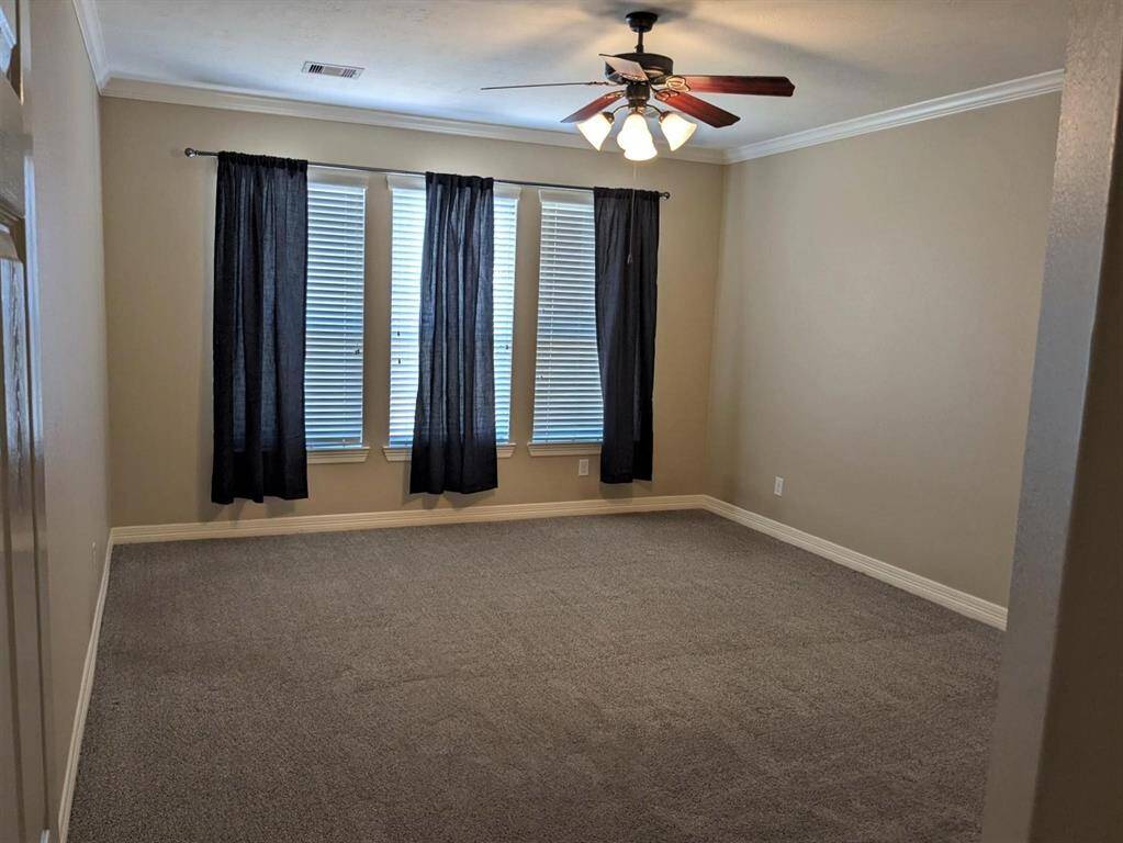 Bright and spacious master bedroom with elegant crown molding and plush carpeting for ultimate comfort.