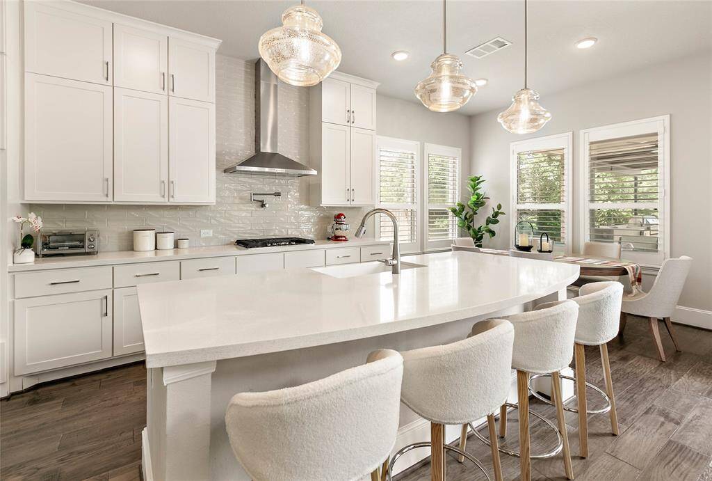 Stainless steel appliances, a gas cooktop and a vent hood make this kitchen both stylish and functional.