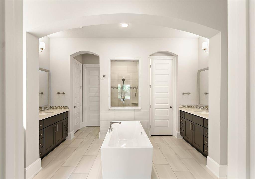 Primary suite bath with dual vanities, make up area, soaking tub and large walk in shower.