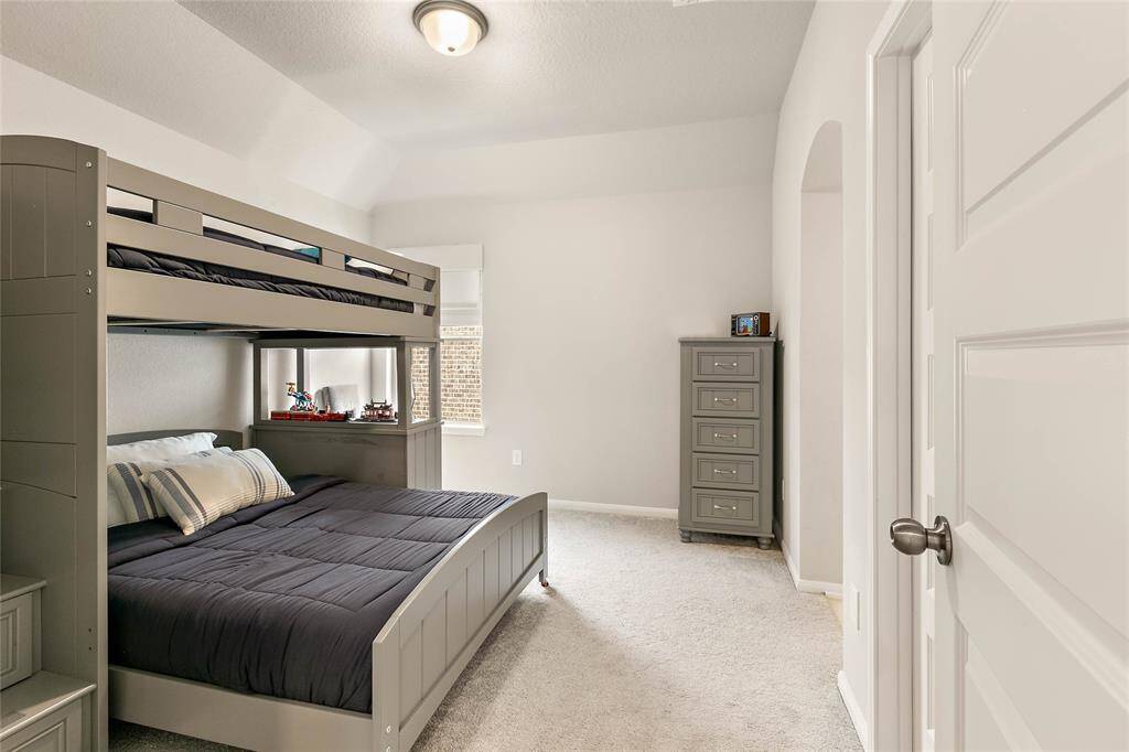 Secondary bedroom with bunk bed, plush carpet and generous closet space.