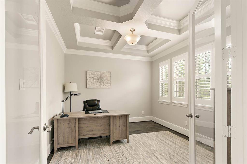 Private home office with French doors, large front-facing windows, and a quiet atmosphere for remote work.